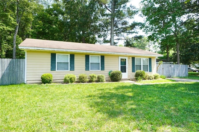 ranch-style house featuring fence and a front lawn