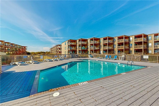 pool featuring a wooden deck and fence