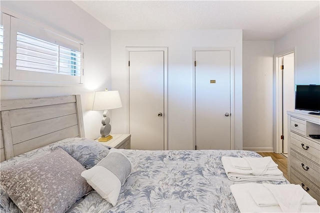 bedroom with baseboards, a closet, and wood finished floors