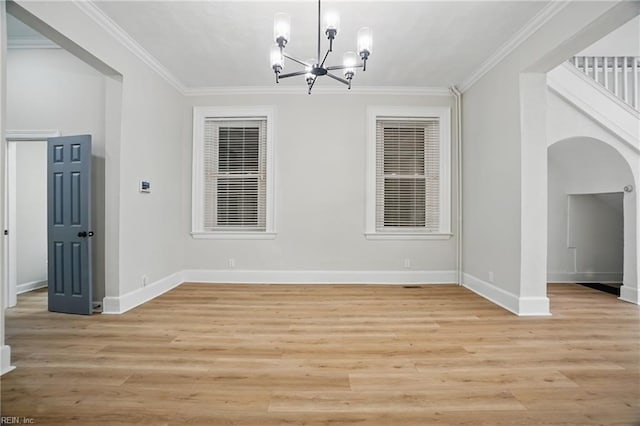 unfurnished dining area featuring crown molding, baseboards, a chandelier, and light wood-style floors