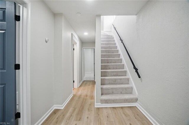 stairway featuring baseboards, recessed lighting, and wood finished floors