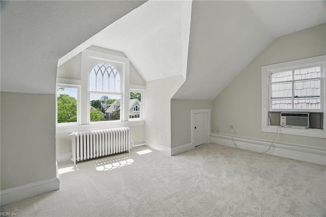 bonus room with carpet floors, baseboards, cooling unit, lofted ceiling, and radiator heating unit