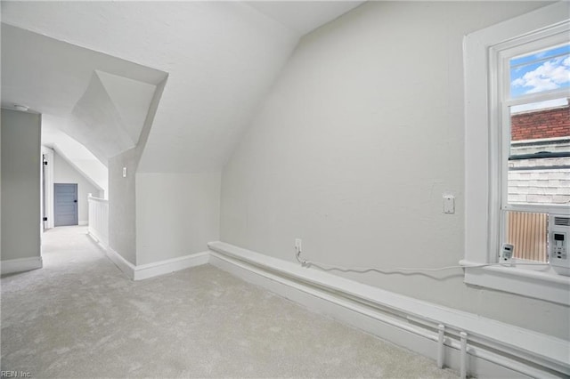 additional living space featuring carpet floors, baseboards, and vaulted ceiling
