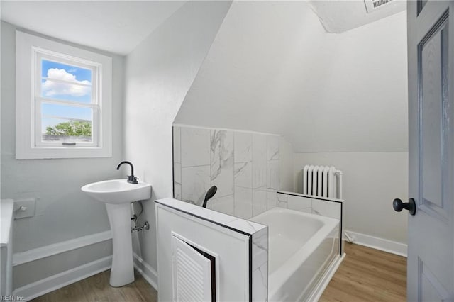 full bath with a garden tub, baseboards, radiator, and wood finished floors