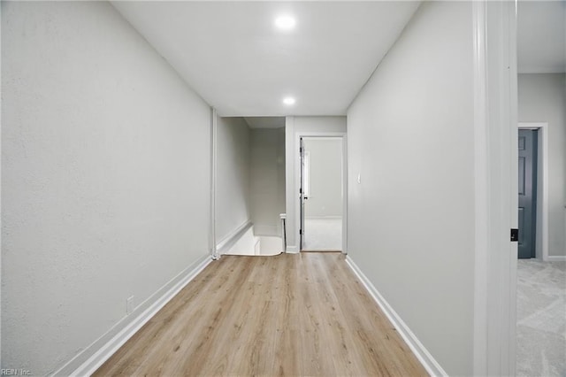 hall with baseboards and light wood-type flooring