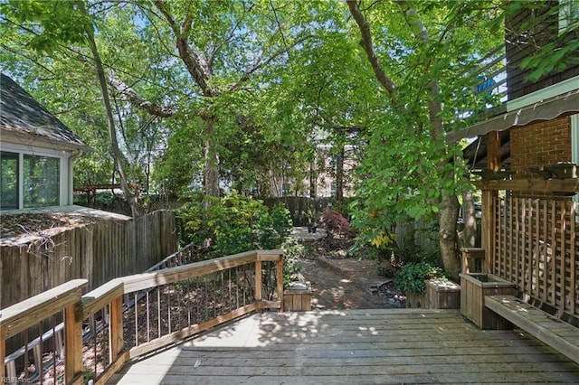 wooden terrace with a fenced backyard