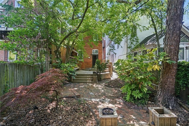 view of yard with a patio area, an outdoor fire pit, and fence