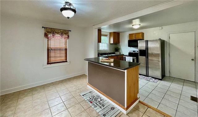 222 Chesterfield Rd, Hampton, VA 23661 - kitchen with appliances with stainless steel finishes, dark countertops, brown cabinetry, light tile patterned floors, and a textured ceiling