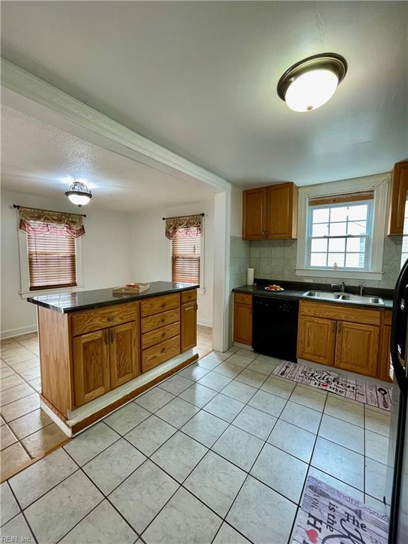 222 Chesterfield Rd, Hampton, VA 23661 - kitchen with black dishwasher, light tile patterned flooring, dark countertops, and tasteful backsplash
