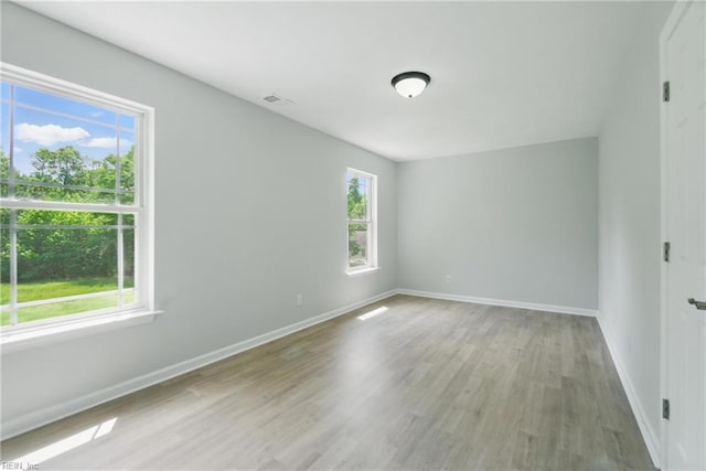 unfurnished room featuring baseboards and light wood-style flooring