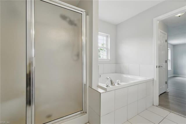 bathroom featuring tile patterned floors, a shower stall, and a garden tub