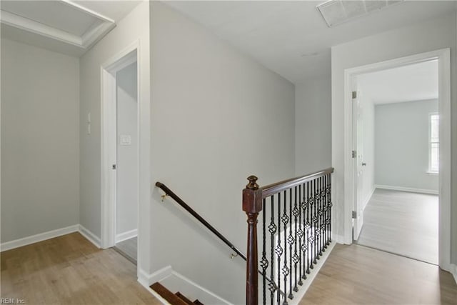 staircase featuring baseboards, attic access, and wood finished floors