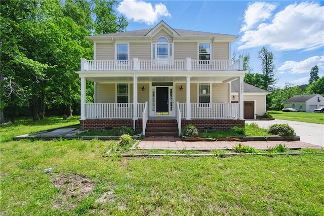 colonial inspired home with a porch, a front lawn, and concrete driveway