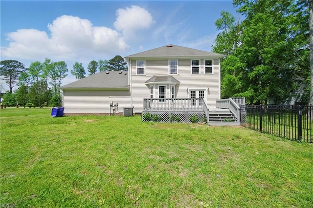 rear view of property featuring fence, a lawn, central AC, and a deck