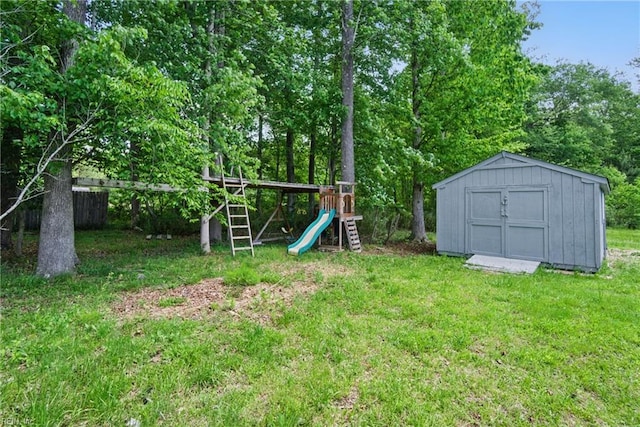 view of yard featuring an outbuilding, a playground, and a storage shed