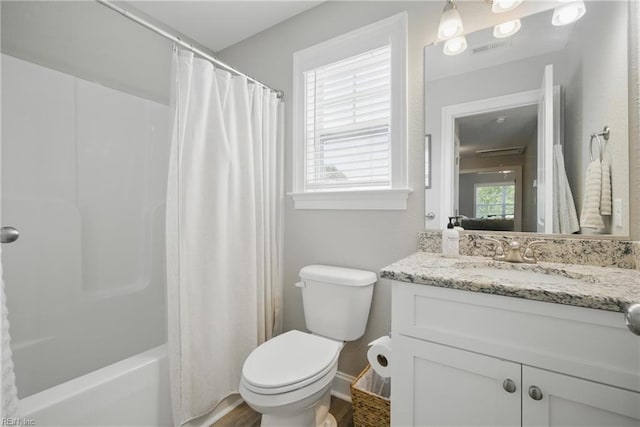 full bath featuring visible vents, shower / tub combo, vanity, baseboards, and toilet