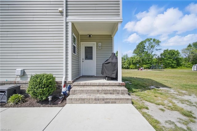 property entrance with a lawn and central air condition unit