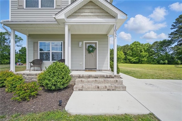 entrance to property with a yard and a porch