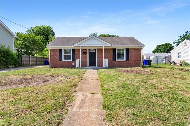 bungalow-style home featuring fence, a front lawn, and brick siding