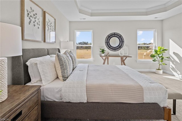 bedroom featuring visible vents, ornamental molding, baseboards, a raised ceiling, and carpet