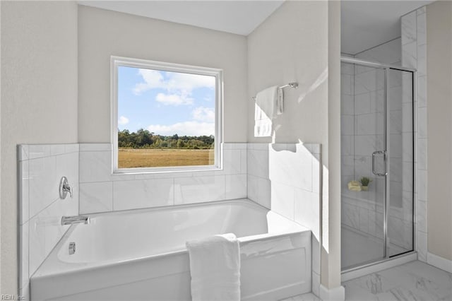 full bath featuring a bath, marble finish floor, and a stall shower