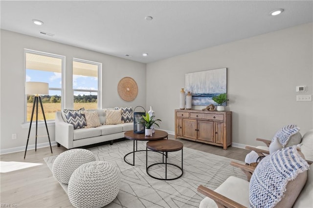 living room featuring baseboards, visible vents, and light wood-style floors