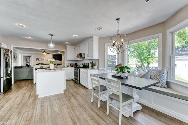 732 Mandarin Ln, Chesapeake, VA 23323 - kitchen featuring white cabinets, a notable chandelier, light wood-style floors, stainless steel appliances, and open floor plan