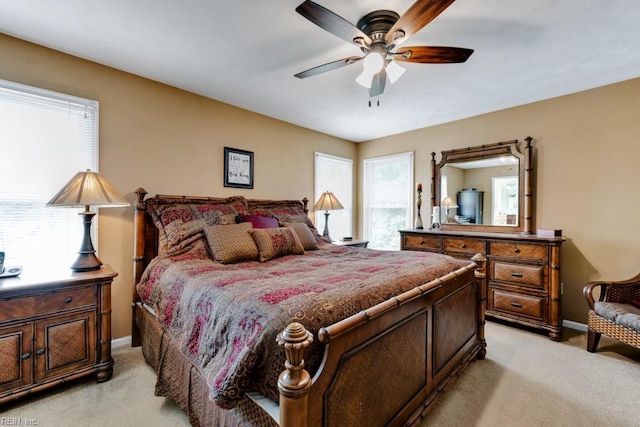 bedroom featuring baseboards, light carpet, and multiple windows