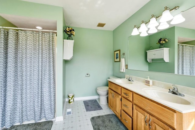 bathroom featuring a sink, baseboards, double vanity, and visible vents