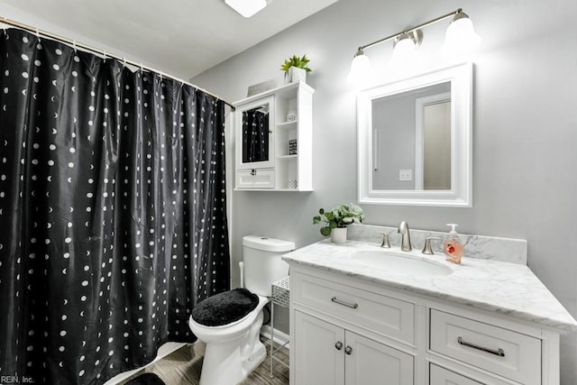 bathroom with toilet, a shower with curtain, wood finished floors, and vanity
