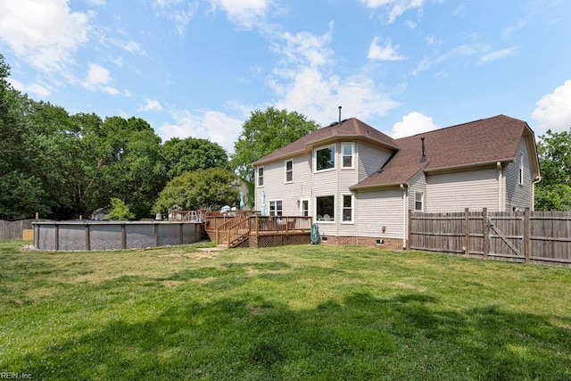 rear view of house featuring a wooden deck, crawl space, a fenced in pool, a lawn, and fence private yard