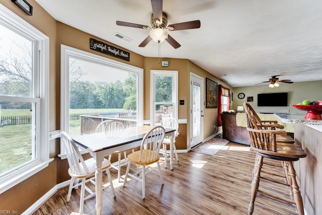 dining room featuring visible vents, a ceiling fan, light wood finished floors, and baseboards