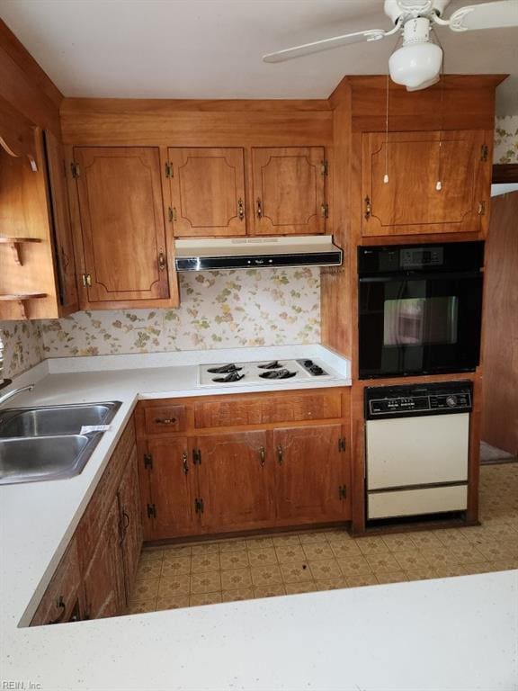 kitchen featuring ceiling fan, a sink, light countertops, white gas stovetop, and under cabinet range hood