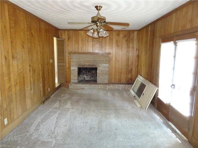 unfurnished living room featuring wooden walls, carpet, and a ceiling fan