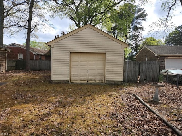 detached garage with fence and dirt driveway