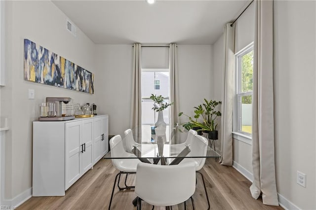 dining area with baseboards, visible vents, a healthy amount of sunlight, and light wood-type flooring