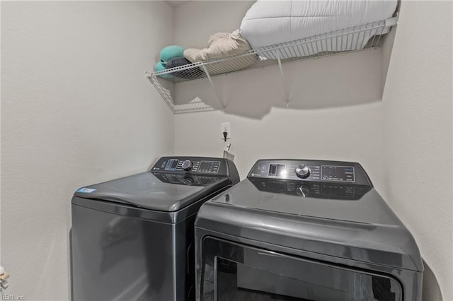 clothes washing area featuring separate washer and dryer and laundry area