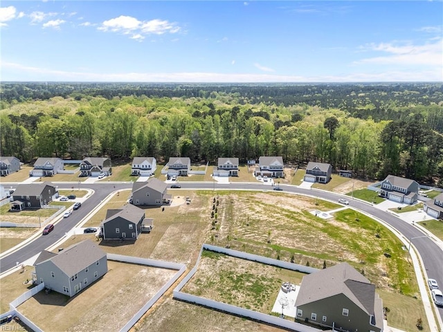 drone / aerial view featuring a residential view and a wooded view