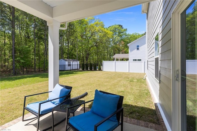 view of yard featuring fence, an outdoor structure, a patio area, and a shed