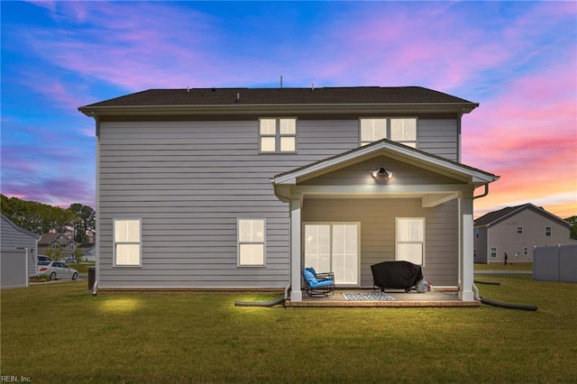 back of house featuring a patio and a yard