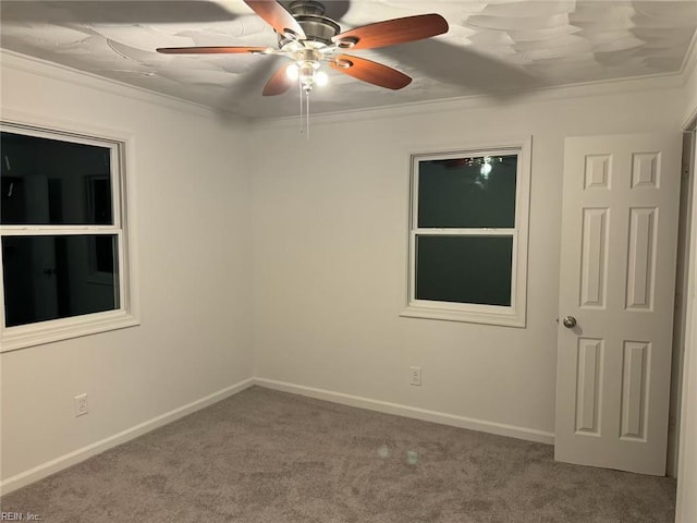 spare room with a ceiling fan, ornamental molding, and carpet