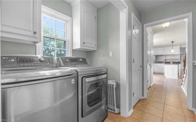 721 Greenwing Dr, Chesapeake, VA 23323 - laundry area with baseboards, washing machine and dryer, cabinet space, and light tile patterned flooring