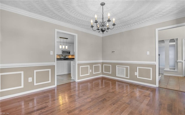 721 Greenwing Dr, Chesapeake, VA 23323 - unfurnished dining area with ornamental molding, wainscoting, wood finished floors, and a chandelier