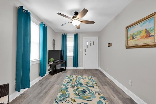 entryway featuring a ceiling fan, baseboards, and wood finished floors