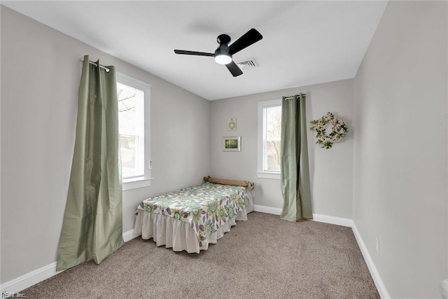 bedroom with carpet floors, multiple windows, baseboards, and a ceiling fan