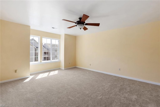 carpeted empty room with baseboards and ceiling fan