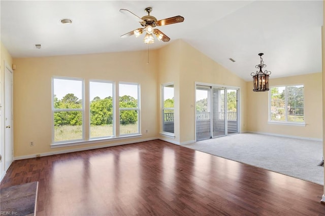 unfurnished living room with lofted ceiling, ceiling fan with notable chandelier, baseboards, and wood finished floors