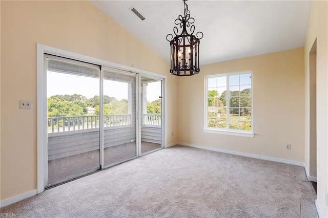 carpeted empty room featuring vaulted ceiling, a chandelier, and baseboards