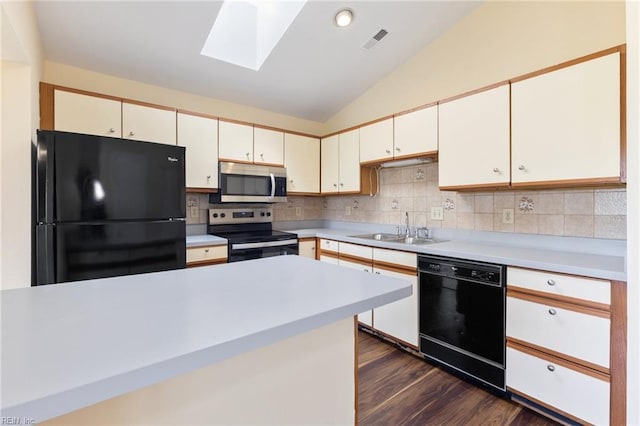 kitchen featuring lofted ceiling with skylight, a sink, visible vents, dark wood-style flooring, and black appliances
