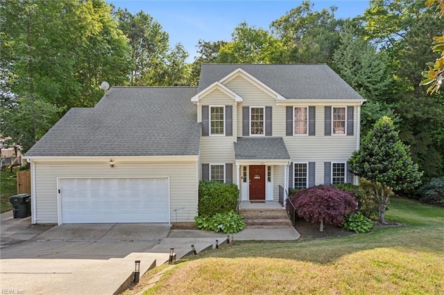 view of front of house with a garage, driveway, and a front lawn